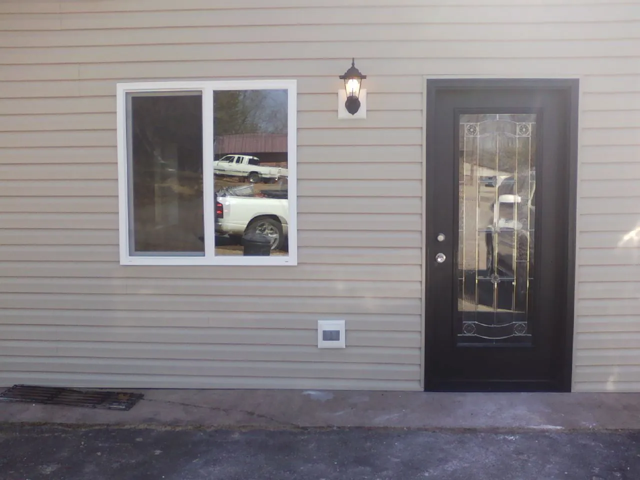 New siding, window and entry door on the side of an addition in Gambell