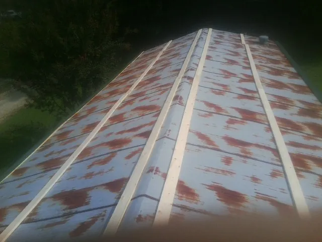 Rusted metal roof panels with new wood purlins before replacement — Storm Damage Roof Repair in Gambell by Roofing Brothers