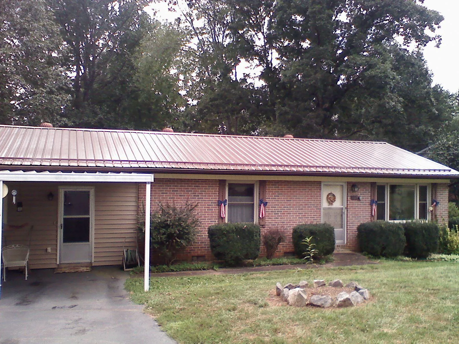 Bronze metal roof and carport on a brick ranch home — Roof Repair work by our crew in Gambell